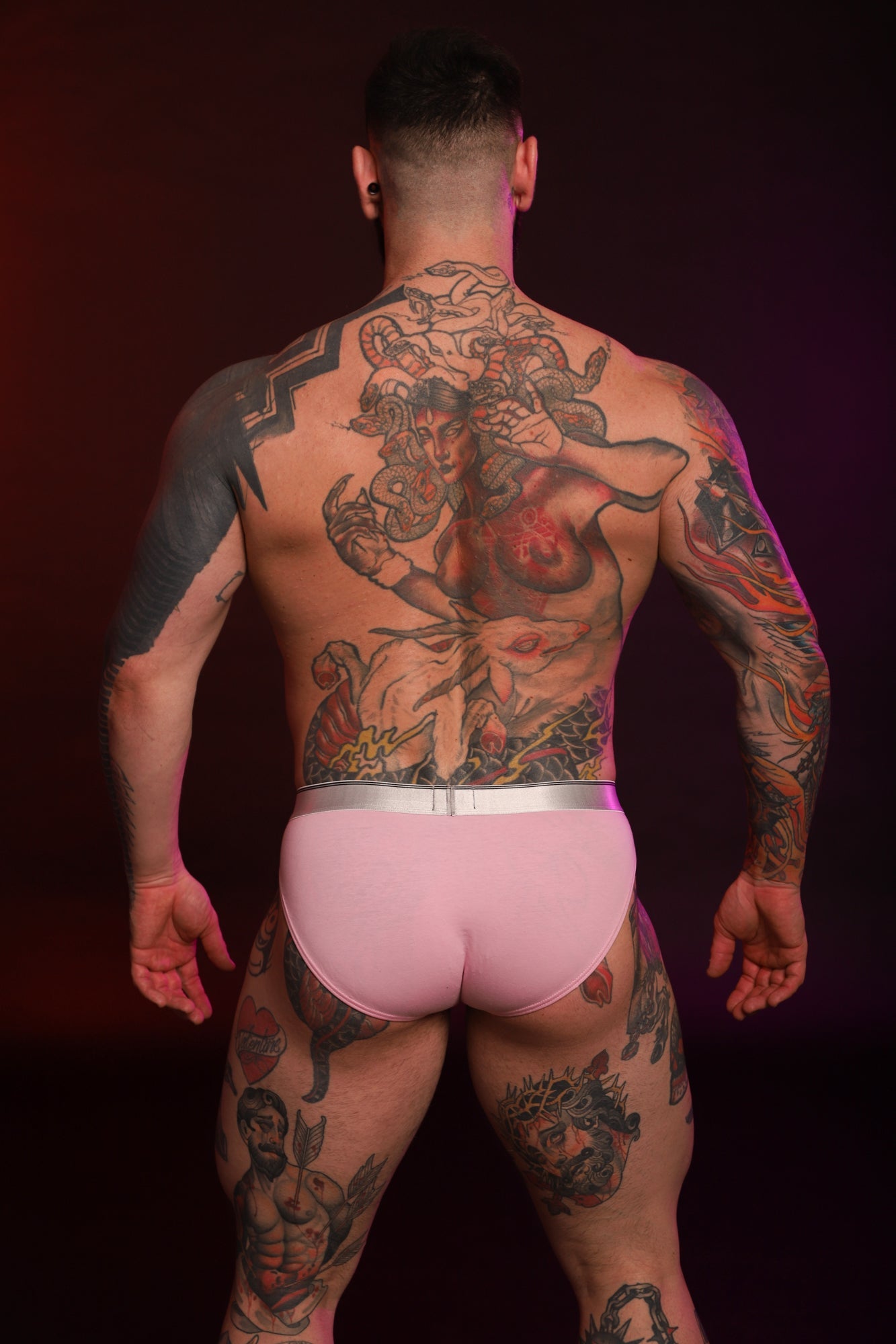 A model facing away from the camera wearing a pair of pink Y2K Briefs.